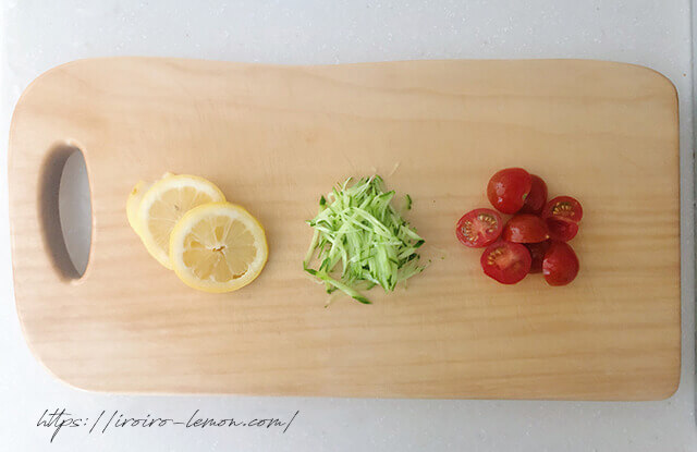 まな板の上のレモン、きゅうり、ミニトマト